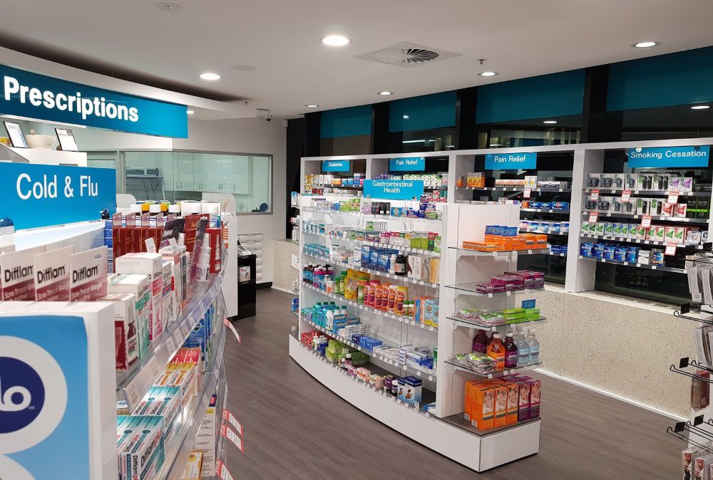 Pharmacy sales floor after LED panel upgrade-bright, even illumination across aisles and counters.