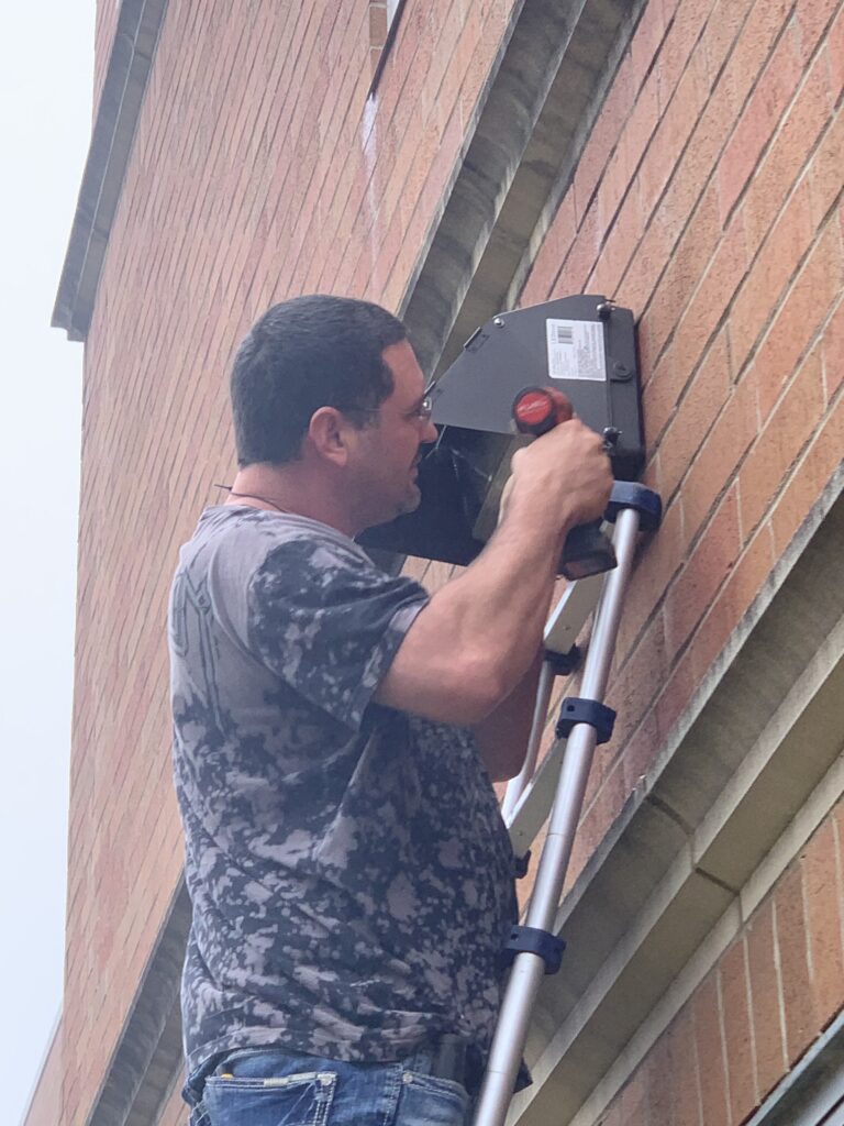 Commercial electrician installing LED Wall Pack at school.